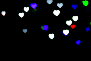 Multicolored bokeh on black background. Heart shape. Love Concept, Valentine's Day. Can be used as a background or wallpaper.