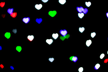 Multicolored bokeh on black background. Heart shape. Love Concept, Valentine's Day. Can be used as a background or wallpaper.