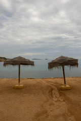 Umbrellas by the sea of Ibiza a cloudy day
