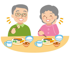 食事をする年配の男女