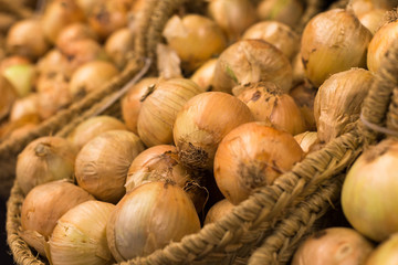 bulb onion in wicker baskets on market counter