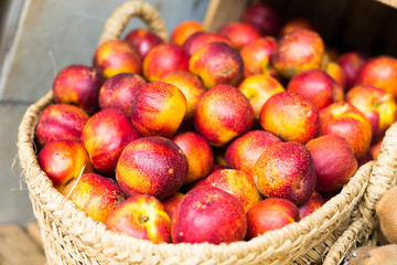 ripe nectarines in wicker baskets on counter