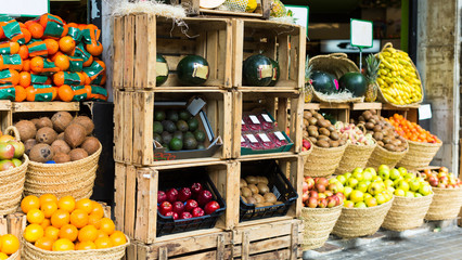 vegetables and fruits in wicker baskets on counter of greengrocery