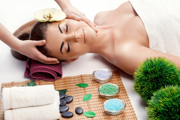 Obraz na płótnie Canvas Attractive Happy relaxing girl at beauty spa treatment. Beauty young woman recieving head massage at spa, massager's hands on the woman's head spa concept. Young woman with Glow, and perfect Skin.