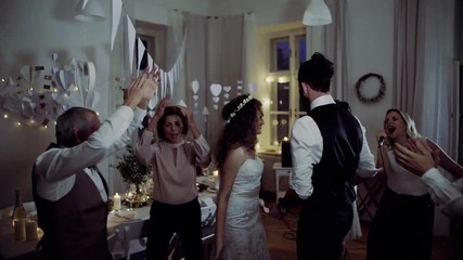 A young bride and groom with other guests dancing on a wedding reception. - Powered by Adobe