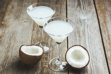 Sweet coconut cocktail in martini glass on the wooden background. Selective focus. Shallow depth of field. 