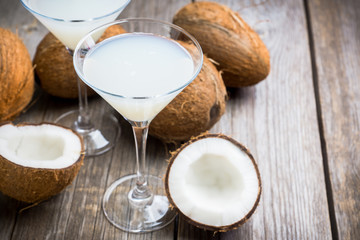 Sweet coconut cocktail in martini glass on the wooden background. Selective focus. Shallow depth of field. 