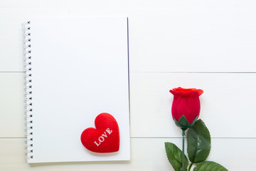 Present red rose flower and notebook and heart shape with copy space on wooden table, 14 February of love day with romantic, valentine holiday concept.