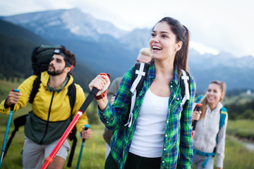 travel, tourism, hike, gesture and people concept - group of smiling friends with backpacks