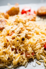 Roasted rice with grilled sausages and bell pepper on the wooden table. Selective focus. Shallow depth of field.