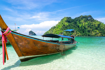 Naklejka na ściany i meble A Thai long tail boat on the beach of Andaman sea located at Krabi near Phuket, Thailand