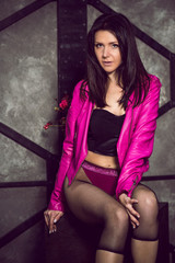 Clothes concept. Woman in fashionable look wearing pink leather jacket and black tights, sexy style 