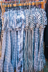 Clothes hanging on a rack in a shopping mall.