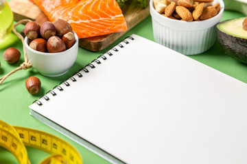 Keto diet concept - salmon, avocado, eggs, nuts and seeds, bright green background, top view