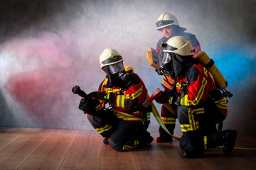 Angriffstrupp mit Atemschutz, Strahlrohr und Feuerwehraxt an der Brandgrenze, begleitet von Atemschutz Überwachung