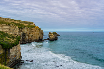 photography of tunnel beach in New Zealand, DUNEDIN, NEW ZEALAND Tunnel beach, Dunedin, South island of New Zealand, amazing coast line from above with a drone, Cliff formations at Tunnel Beach