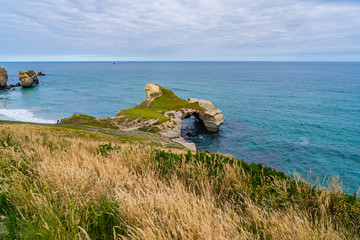 photography of tunnel beach in New Zealand, DUNEDIN, NEW ZEALAND Tunnel beach, Dunedin, South island of New Zealand, amazing coast line from above with a drone, Cliff formations at Tunnel Beach