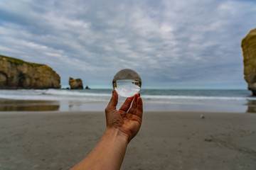 crystal ball on tunnel beach in New Zealand, lansball on the beach, amazing tunnel beach in New Zealand with a crystal ball in the foreground, crystal ball on tunnel beach in New Zealand, lansball on 