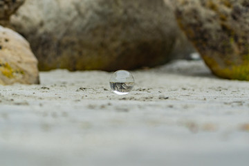 crystal ball on tunnel beach in New Zealand with rocks in the background, lansball on the beach, amazing tunnel beach in New Zealand with a crystal ball in the foreground,