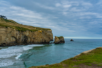 Fototapeta premium photography of tunnel beach in New Zealand, DUNEDIN, NEW ZEALAND Tunnel beach, Dunedin, South island of New Zealand, amazing coast line from above with a drone, Cliff formations at Tunnel Beach