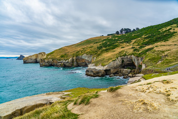 photography of tunnel beach in New Zealand, DUNEDIN, NEW ZEALAND Tunnel beach, Dunedin, South island of New Zealand, amazing coast line from above with a drone, Cliff formations at Tunnel Beach