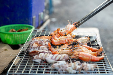 Professional Chef Cooking  Prawns or shrimp grilled on charcoal stove. shrimp grilled bbq seafood on stove.Closed up river prawn charcoal grilled on stove with Thai style homemade.