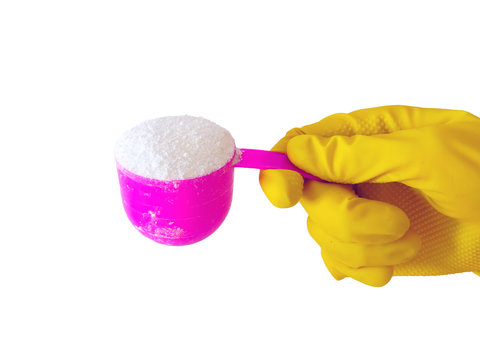 Employee hand in rubber protective glove with pink cup or scoop . Getting started cleaning.  Commercial cleaning company. Copy space. Detergent for clothes washing. Regular washing.
