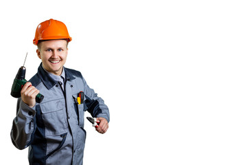 A young builder and engineer with a drill and pliers in his hands, ready to make for you a quality repair. The concept of repair and construction. isolated.