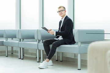 businessman reading a business document sitting in the office lobby