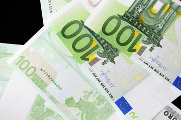One Hundred euro banknotes on a dark background close up