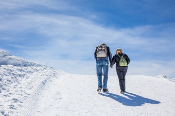 Husband and wife are walking on the snow at Titlis - Gadmen, Switzerland