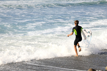 surfista con tabla metiendose al agua 4M0A3667-A19