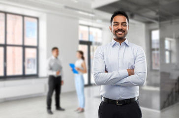 Fototapeta premium business, realty and people concept - smiling indian businessman or realtor over empty office room background