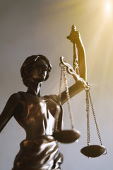 lady justice or justitia blindfolded figurine holding balance scales - law and legal symbol - with...