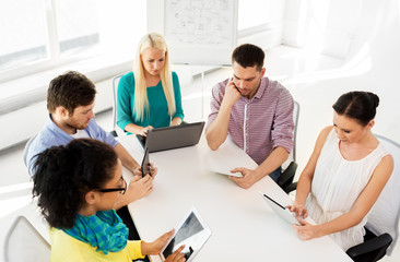 business, technology and startup concept - creative team with table pc computers in office