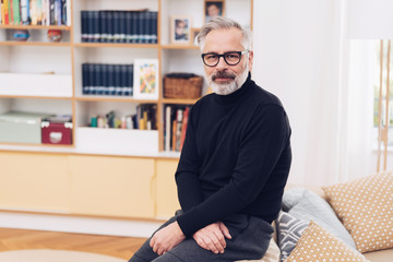 Mature man in black sweater and glasses at home