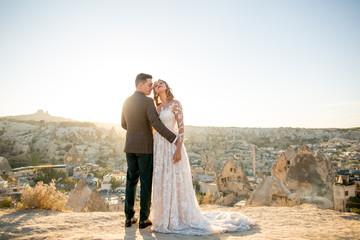 Beautiful wedding couple posing at peak near Cappadocia Turkey