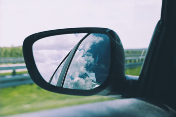 Landscape in the sideview mirror of a car