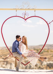 beautiful woman and handsome man posing in swing