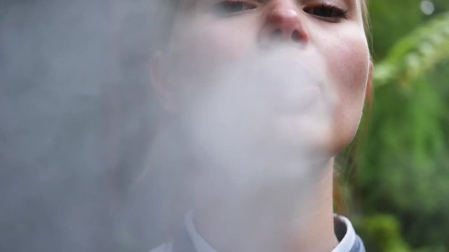 girl uses vape in park