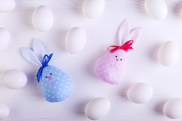 White eggs pattern, including two handmade Easter bunny, blue and pink.