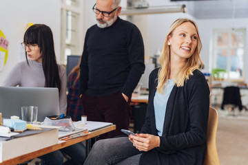 Smiling woman looking back. Office life scene