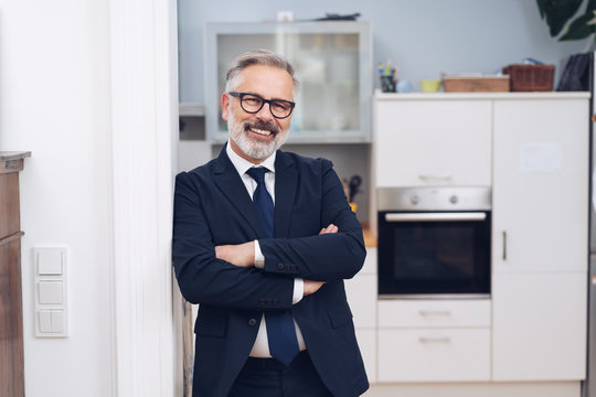 Smiling mature man in suit and glasses at home
