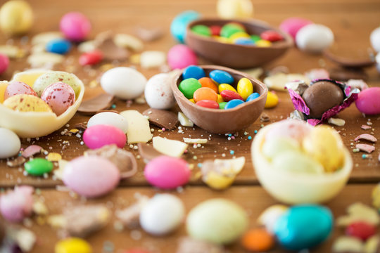 easter, junk-food, confectionery and unhealthy eating concept - close up of chocolate eggs and candy drops on table