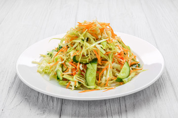 Fresh vegetable salad with cabbage, carrot, green onion and cucumber