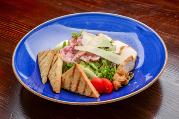Chicken Caesar Salad. Caesar Salad with grilled chicken on plate. Grilled chicken breasts and fresh salad in plate