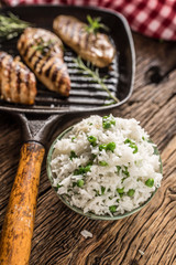 Rice basmati with green peas in bowl and grilled chicken breast in the background