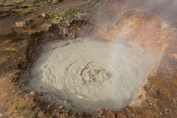 bubbling mud pot in iceland, drops, vapor, sunlight