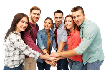 friendship and people concept - group of smiling friends stacking hands over white background