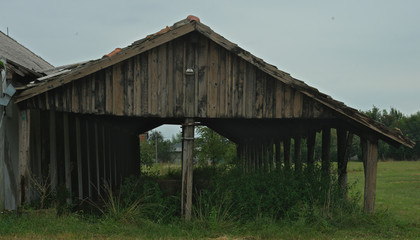 Long shed next to stable on a large field, front view